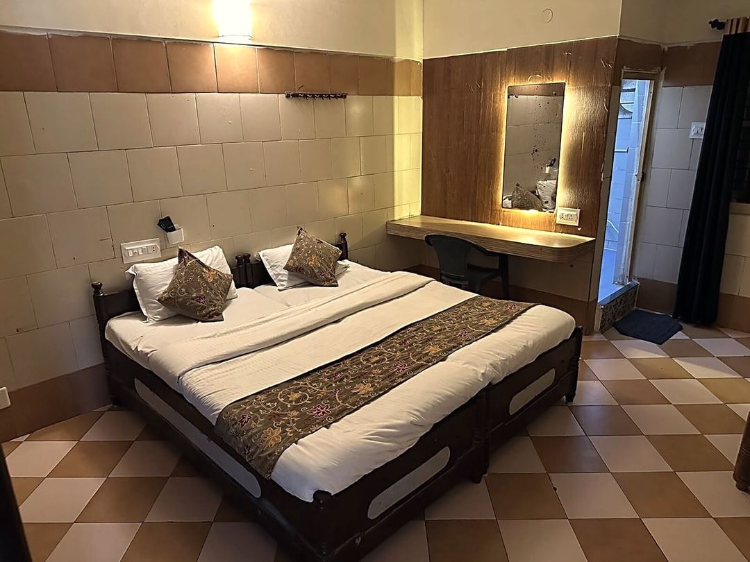 Double room from the doorway showing the desk, mirror and en-suite bathroom entrance