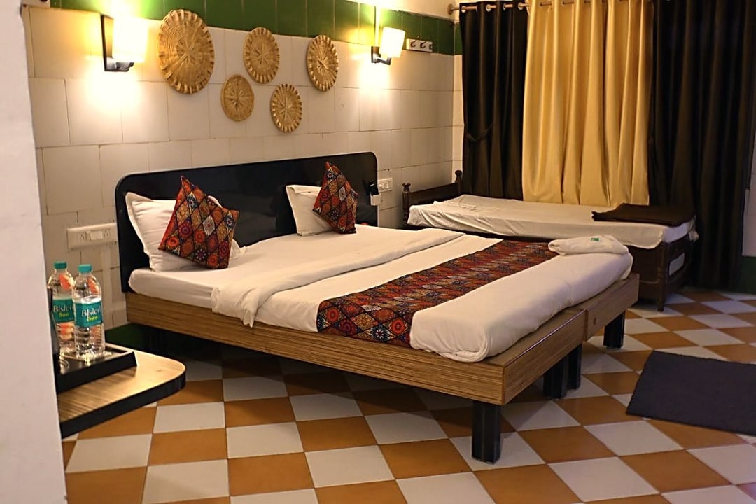 Premium non air conditioned room at Cibara Comforts with a queen bed and warm wall lighting